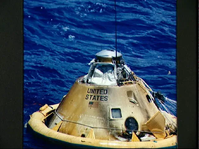 An Apollo command module floating in the ocean after reentering the Earths atmosphere